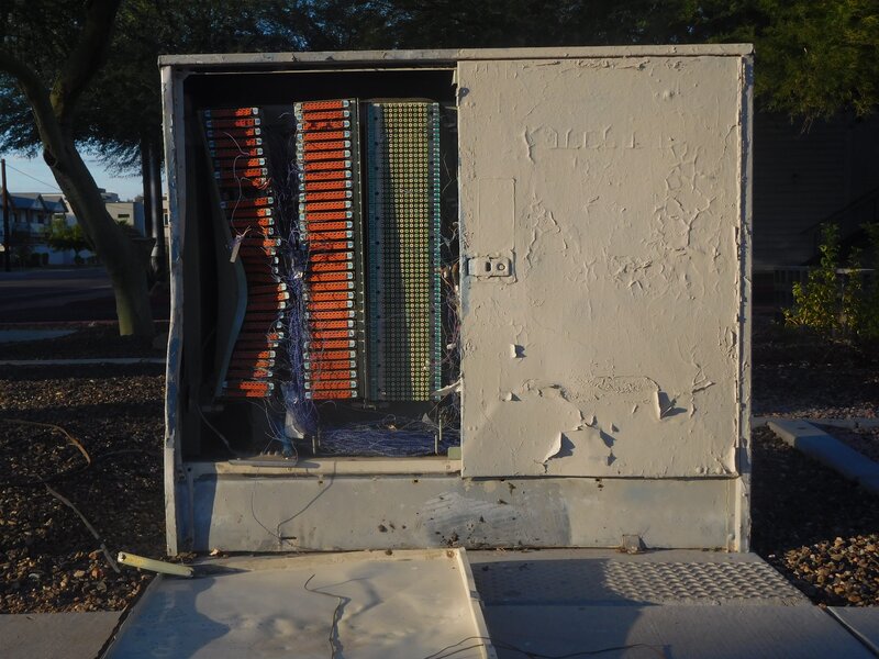 Some kind of a telecommunications utility box with all of its innards exposed.